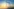 Im Vordergrund ist eine Solaranlage und im Hintergrund ist ein öffentlicher Hochspannungsmast und am Horizont ist der Sonnenaufgang zu sehen.